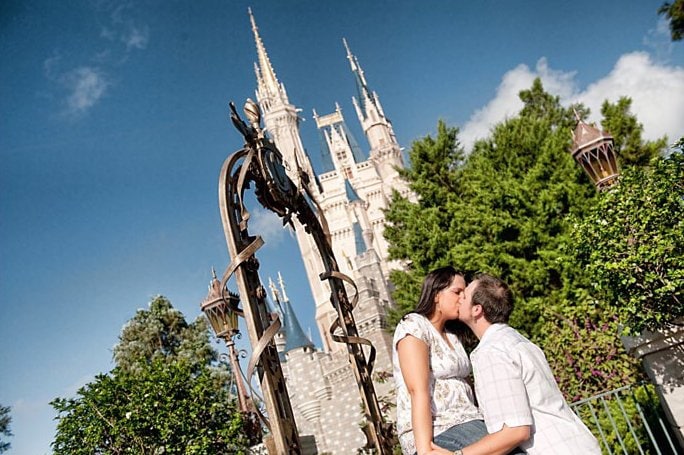 A honeymoon at Walt Disney World is worth every moment. Here is why! #disneymoon #disneyhoneymoon couple kissing in front of cinderella castle