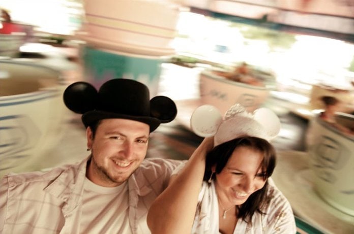 A honeymoon at Walt Disney World is worth every moment. Here is why! #disneymoon #disneyhoneymoon couple in spinning teacups at walt disney world