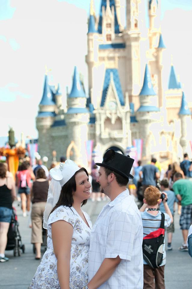A honeymoon at Walt Disney World is worth every moment. Here is why! #disneymoon #disneyhoneymoon newly wed couple in honeymoon mickey ears in front of cinderella castle