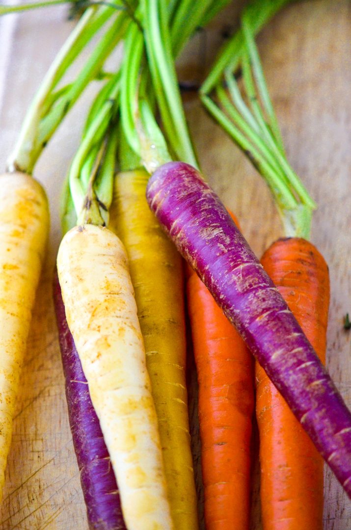 colorful organic carrots on cutting board