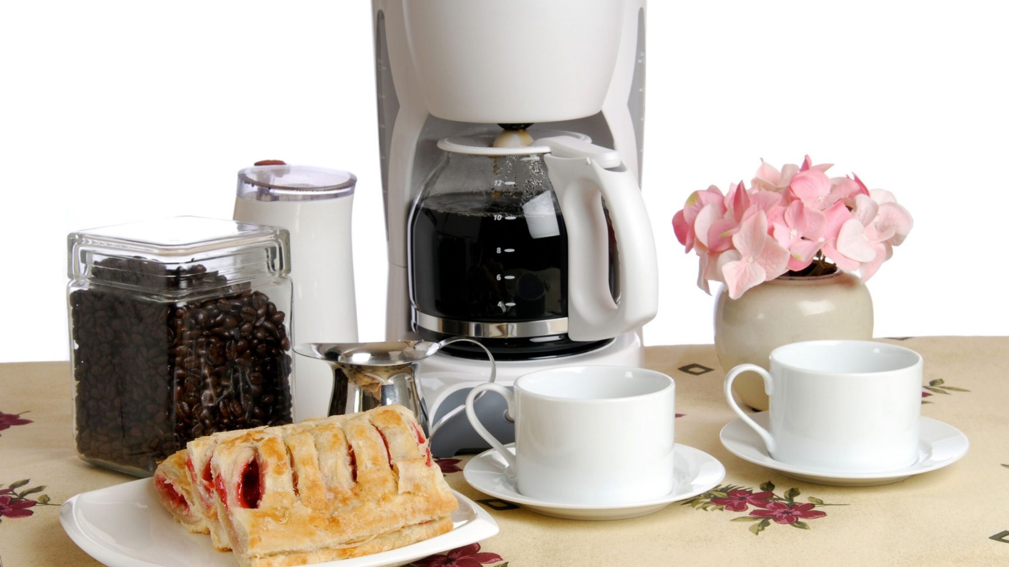 coffee maker with pastry and coffee mug